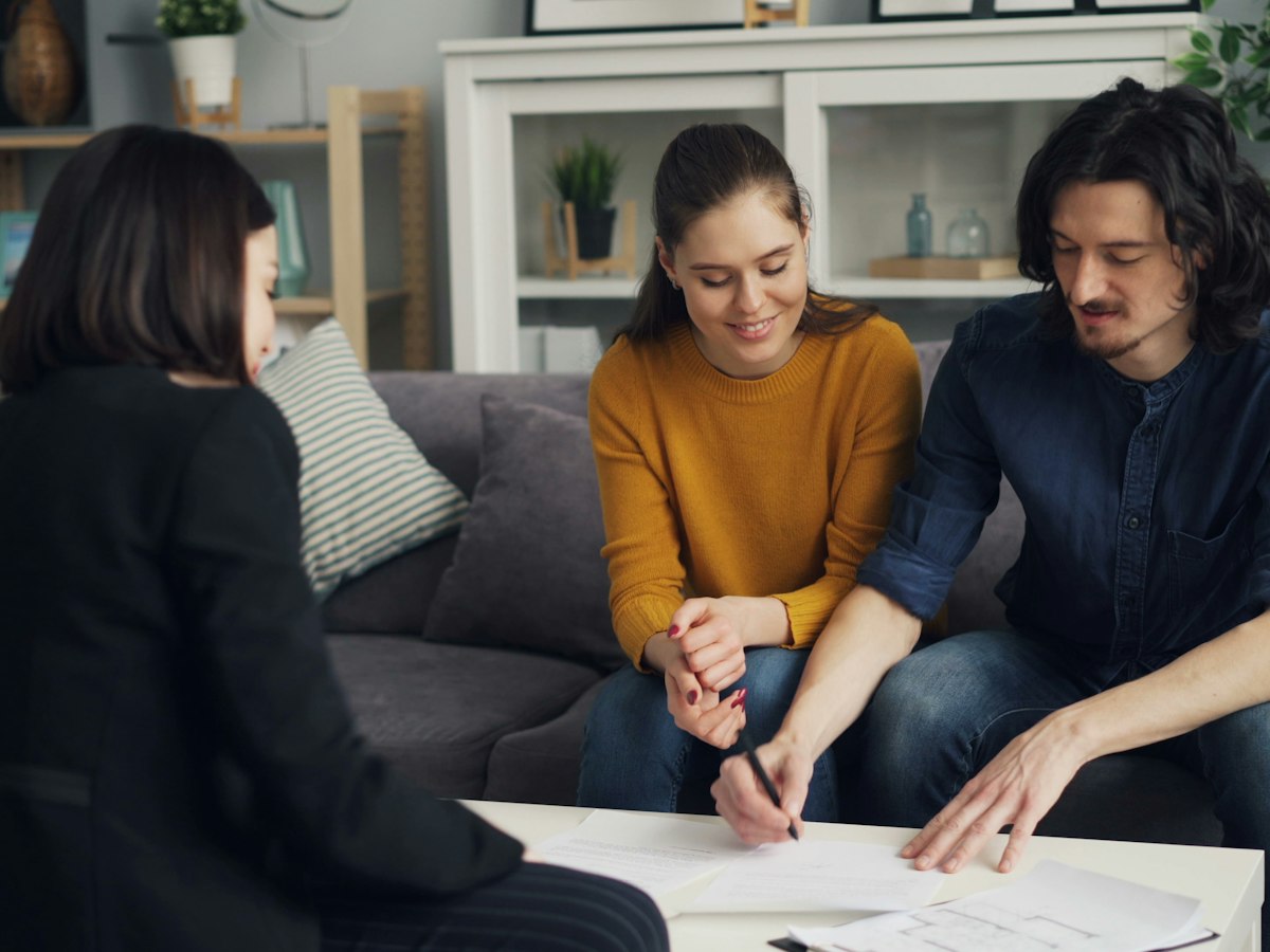 An adviser sitting with a couple as they work through paperwork together